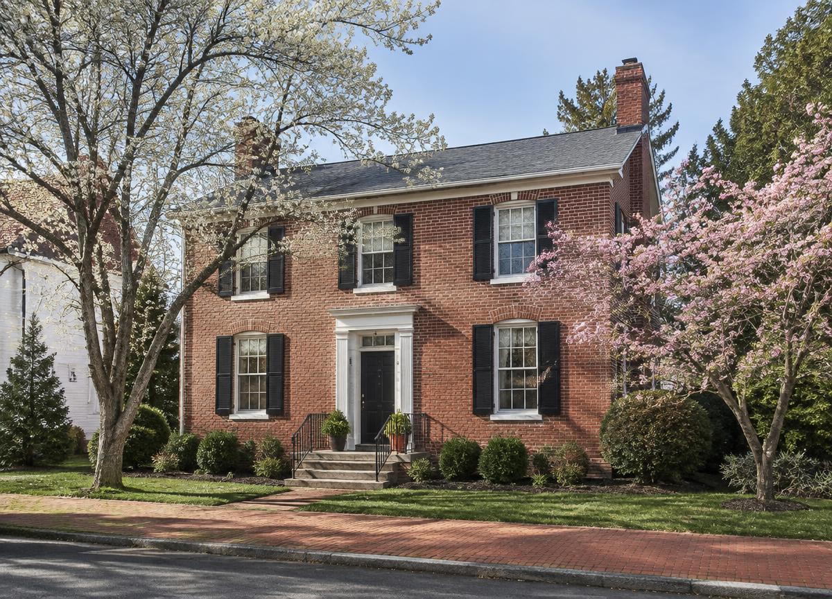 Red-brick colonial home on a tree-lined street in a historic Delaware town